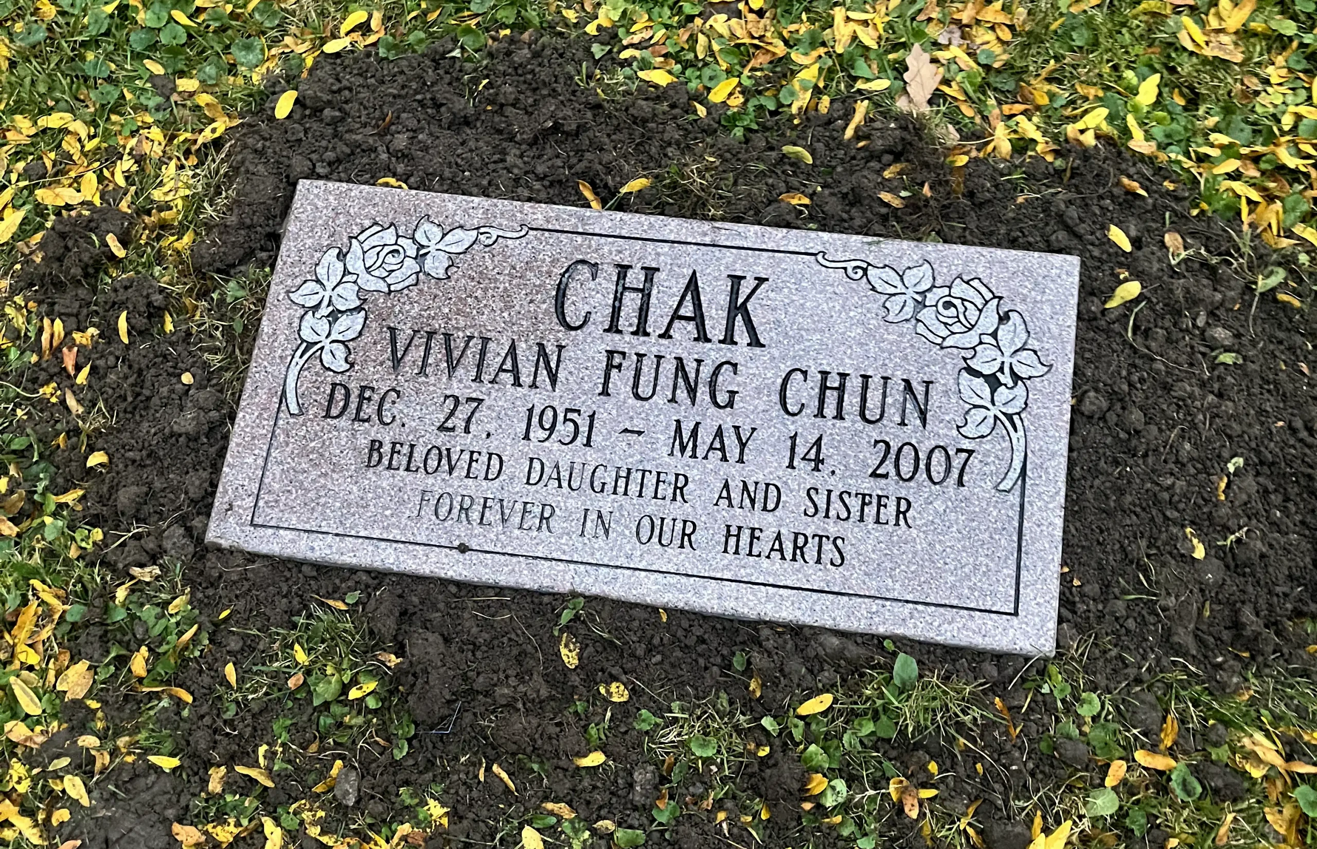 Redish gray granite marker with flower engravings.